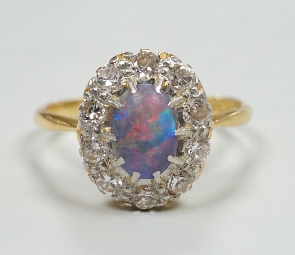 An early 20th century 18ct, black opal and diamond set oval cluster ring, size O, gross weight 2.8 grams.